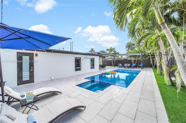 view of swimming pool with a patio, a fenced backyard, and a pool with connected hot tub