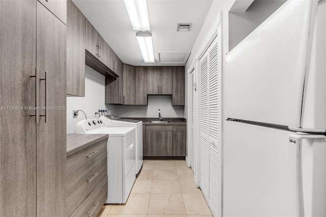 laundry room featuring cabinets, sink, and independent washer and dryer