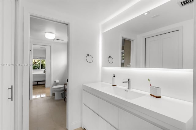 bathroom featuring tile patterned floors, vanity, and toilet