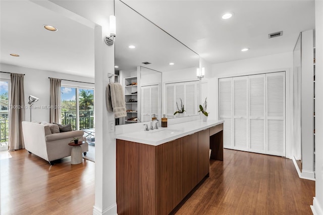 kitchen with sink, kitchen peninsula, dark hardwood / wood-style floors, and decorative light fixtures