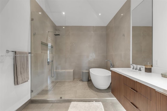 bathroom featuring lofted ceiling, tile walls, tile patterned flooring, vanity, and separate shower and tub