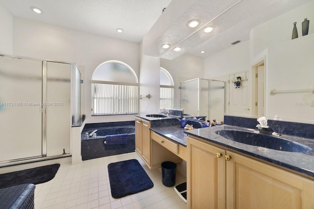 bathroom with a textured ceiling, tile patterned floors, vanity, and separate shower and tub