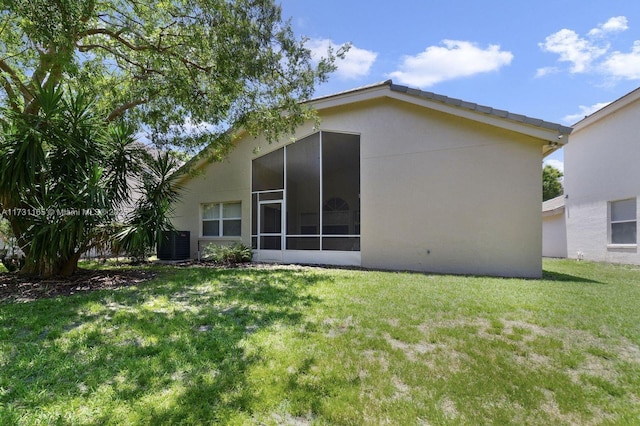 back of house featuring a yard and central AC