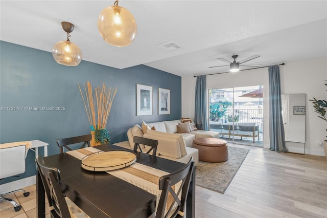 dining space with ceiling fan and light hardwood / wood-style flooring