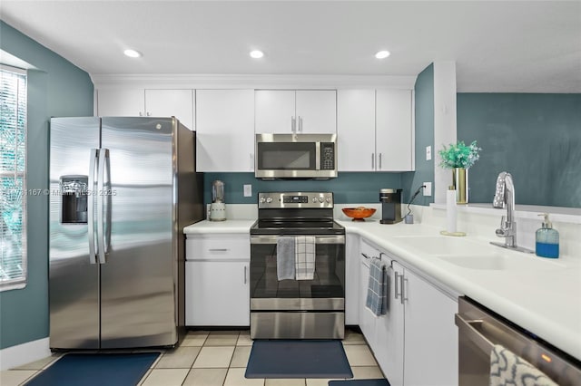 kitchen featuring sink, light tile patterned flooring, white cabinets, and appliances with stainless steel finishes