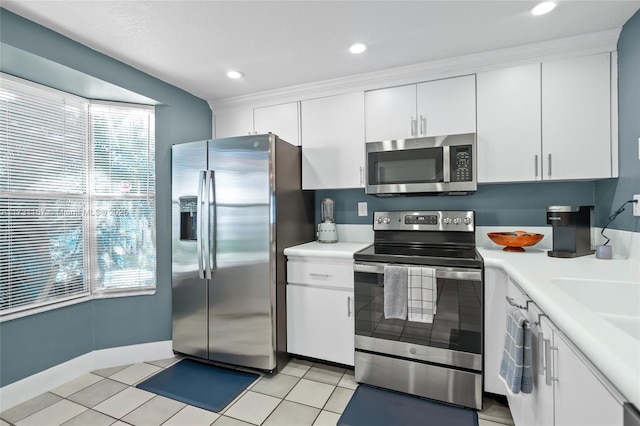 kitchen with stainless steel appliances, white cabinetry, and light tile patterned floors