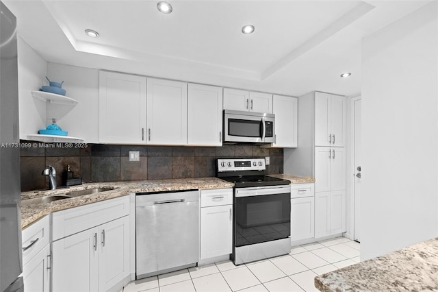 kitchen with white cabinets, a raised ceiling, and appliances with stainless steel finishes