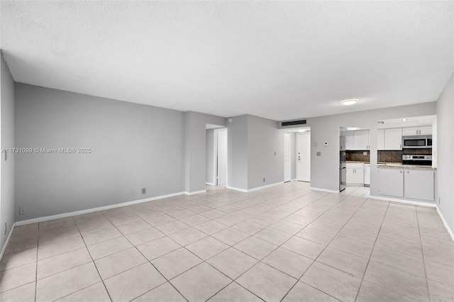 unfurnished living room featuring a textured ceiling and light tile patterned floors