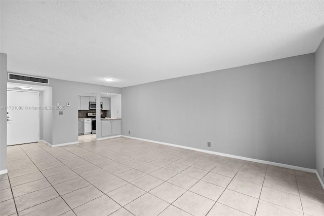 unfurnished living room with a textured ceiling and light tile patterned floors