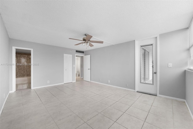 spare room with ceiling fan, a textured ceiling, and light tile patterned floors