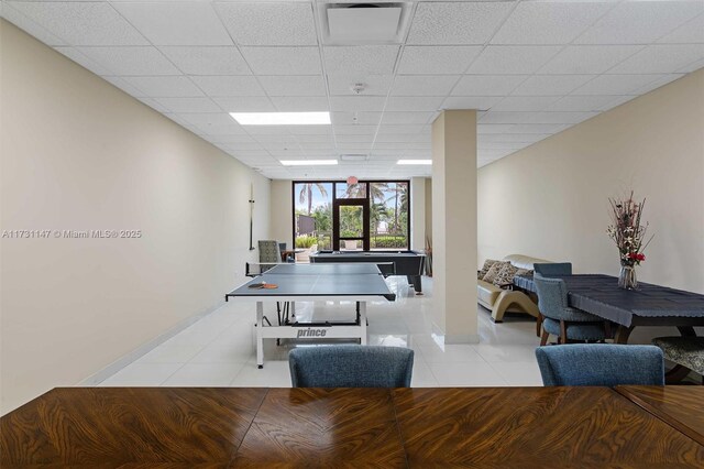 game room with light tile patterned floors and a paneled ceiling