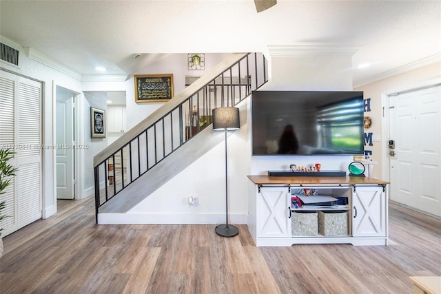 stairway featuring crown molding and hardwood / wood-style floors