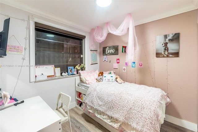 bedroom with ornamental molding and wood-type flooring