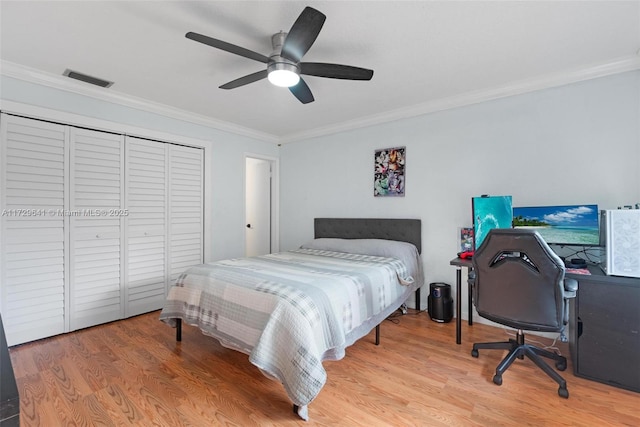 bedroom featuring light hardwood / wood-style flooring, a closet, ceiling fan, and ornamental molding