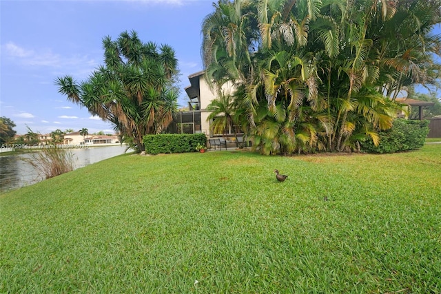 view of yard featuring a water view and a lanai