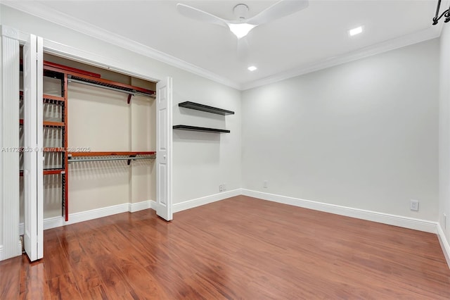 unfurnished bedroom featuring crown molding, ceiling fan, a closet, and hardwood / wood-style flooring