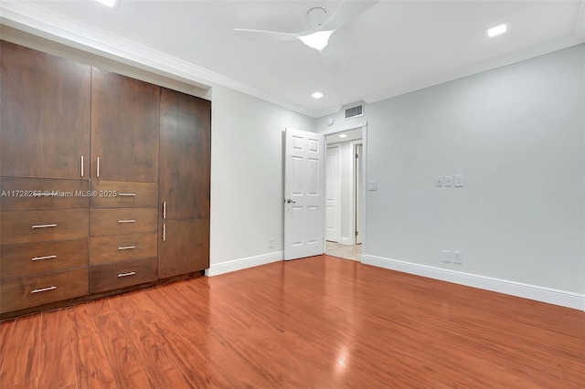 unfurnished bedroom with crown molding, hardwood / wood-style floors, and ceiling fan