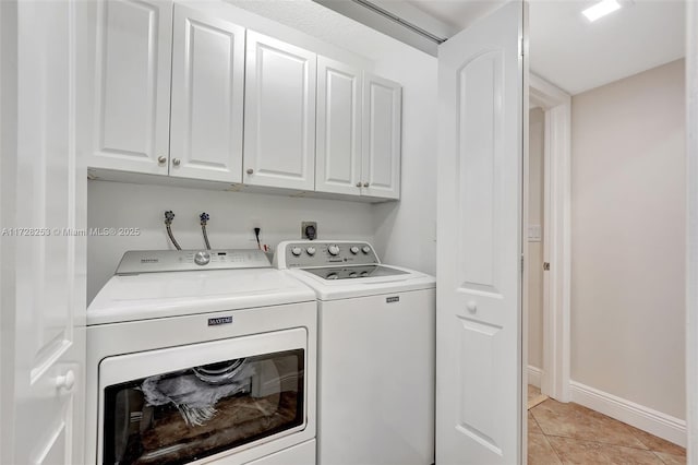 laundry room with cabinets, separate washer and dryer, and light tile patterned floors