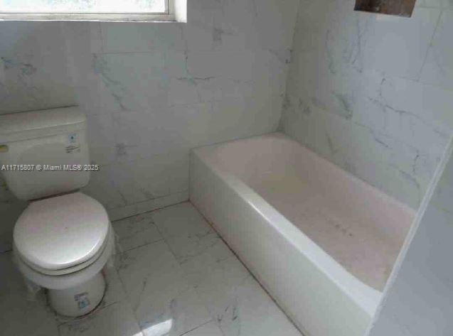 bathroom featuring a bathtub and toilet