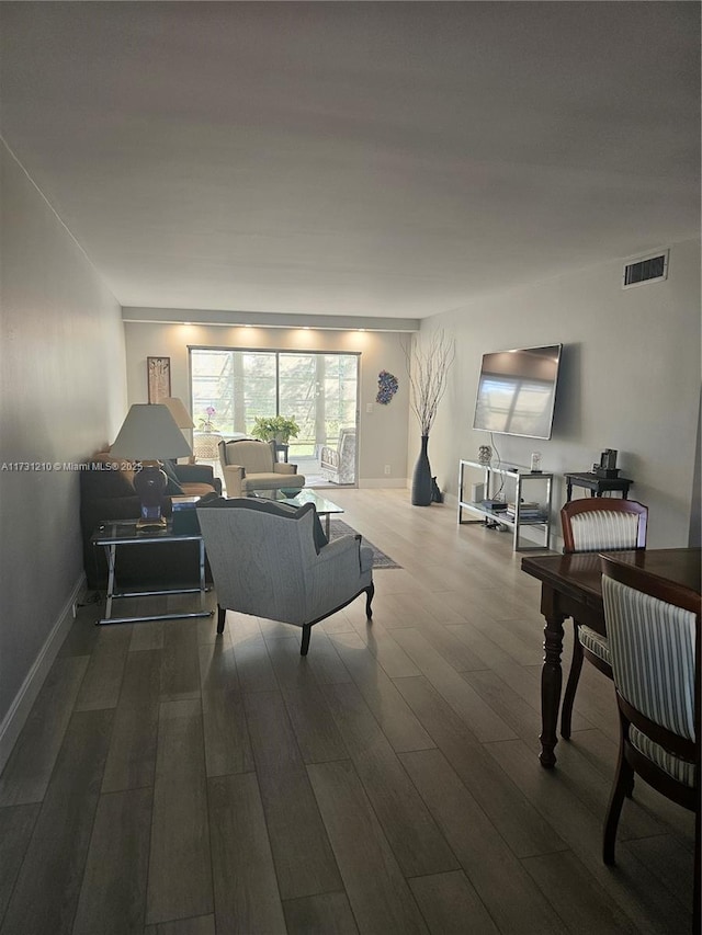 living room with visible vents, baseboards, and wood finished floors