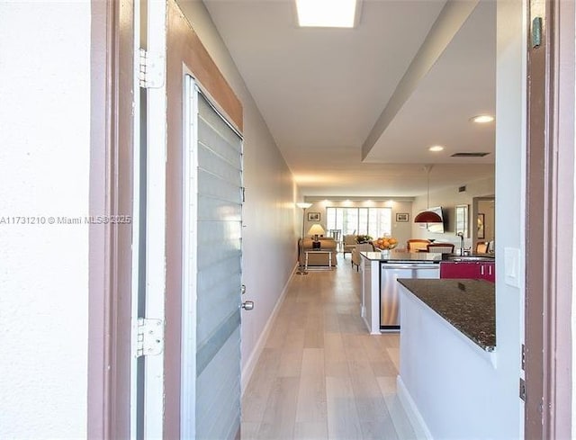 hallway with sink and light hardwood / wood-style flooring