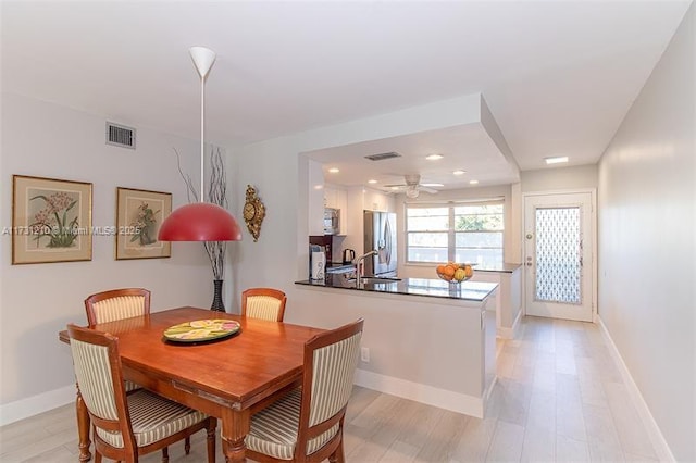 dining space with ceiling fan, sink, and light hardwood / wood-style floors