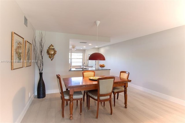 dining room featuring sink and light hardwood / wood-style floors