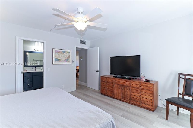 bedroom featuring ceiling fan, ensuite bathroom, sink, and light hardwood / wood-style floors