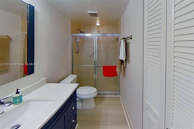 bathroom featuring toilet, hardwood / wood-style floors, vanity, and a shower with shower door