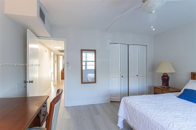 bedroom featuring ceiling fan, a closet, and light wood-type flooring