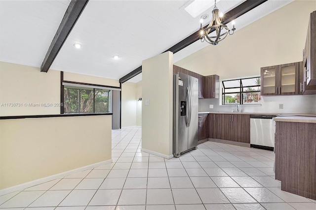 kitchen with sink, vaulted ceiling with beams, dark brown cabinets, pendant lighting, and stainless steel appliances