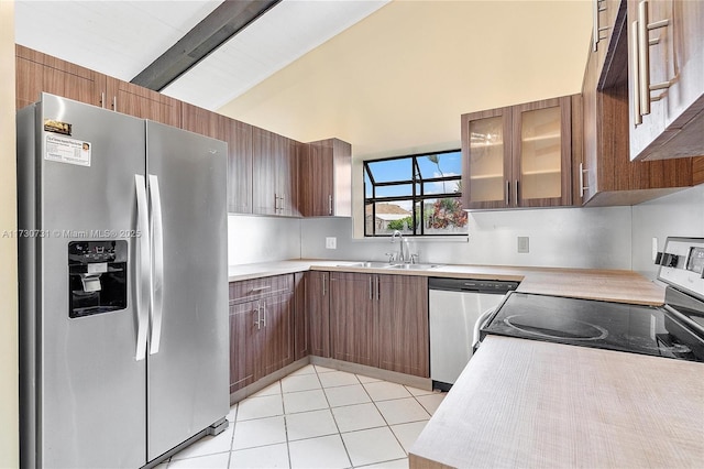 kitchen with sink, high vaulted ceiling, light tile patterned floors, appliances with stainless steel finishes, and beamed ceiling