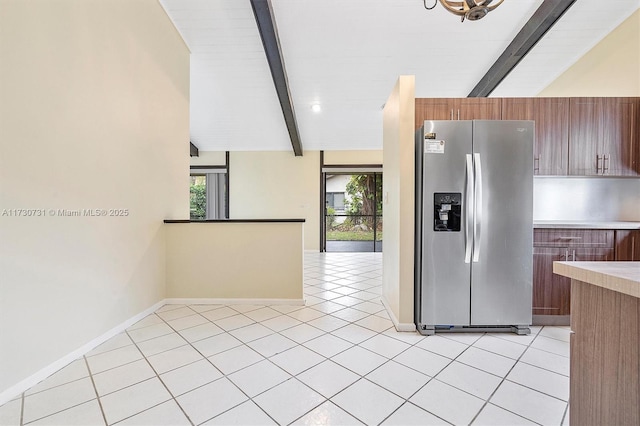 kitchen featuring light tile patterned flooring, lofted ceiling with beams, and stainless steel refrigerator with ice dispenser