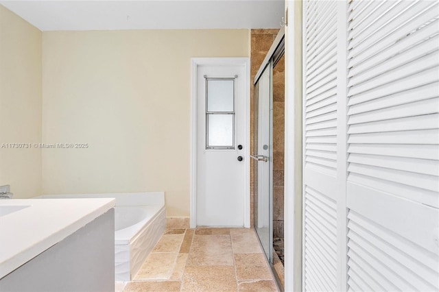 bathroom with vanity and shower with separate bathtub