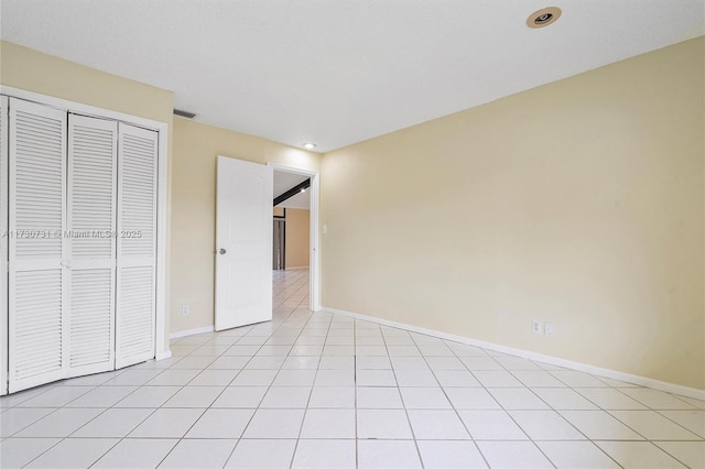 unfurnished bedroom featuring light tile patterned floors and a closet