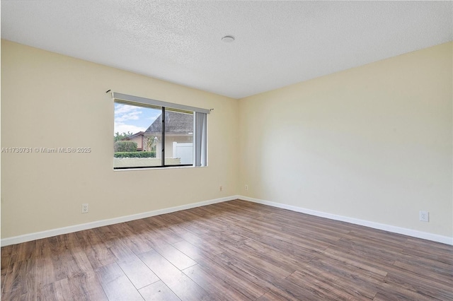 unfurnished room featuring hardwood / wood-style flooring and a textured ceiling