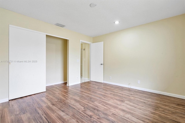 unfurnished bedroom featuring hardwood / wood-style flooring and a textured ceiling