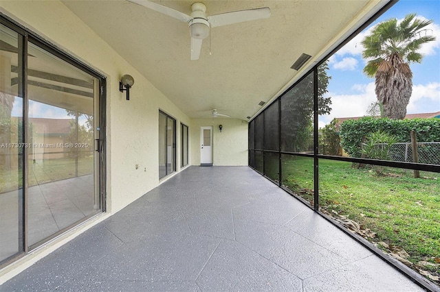 unfurnished sunroom featuring ceiling fan