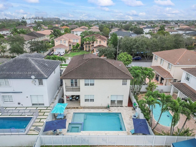 view of pool with a pool with connected hot tub, a patio area, a fenced backyard, and a residential view