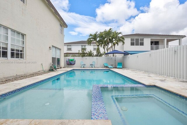 view of swimming pool with an in ground hot tub and a patio