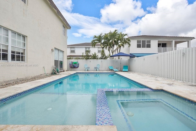 view of pool with fence private yard, a pool with connected hot tub, and a patio