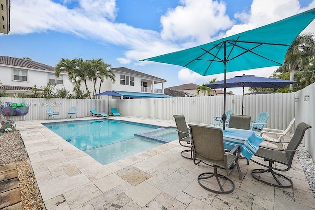 view of pool featuring a patio, a fenced backyard, and a pool with connected hot tub