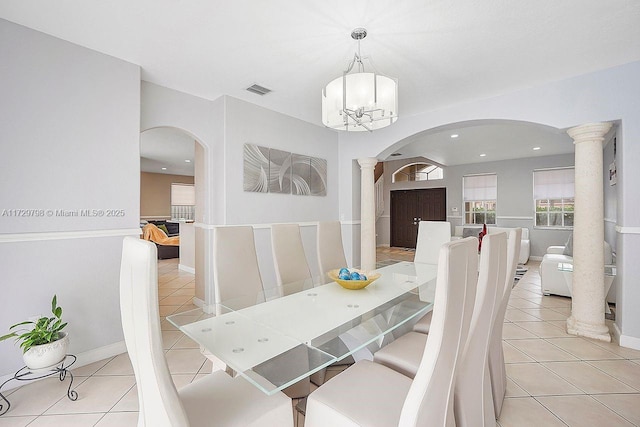 dining space with arched walkways, decorative columns, light tile patterned floors, visible vents, and baseboards