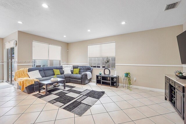 tiled living room featuring a textured ceiling