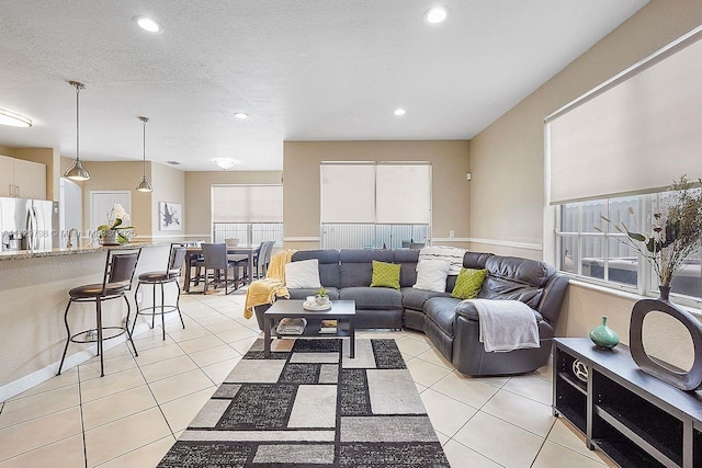 living room with a textured ceiling, light tile patterned flooring, and recessed lighting