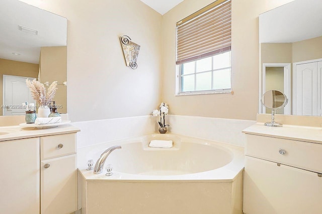 full bathroom with visible vents, a bath, and vanity