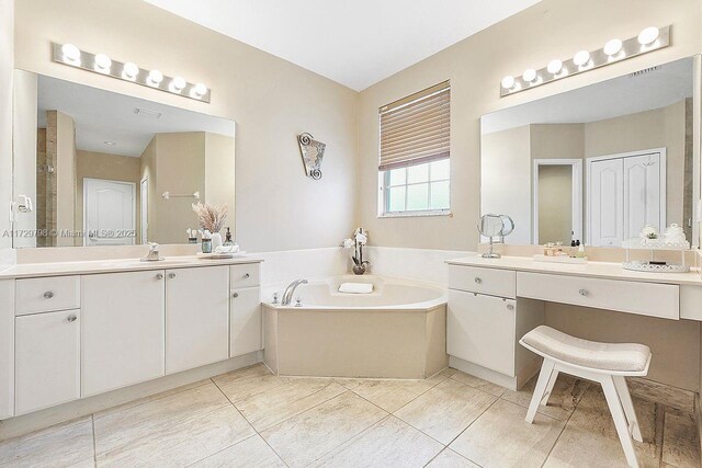 bathroom with vanity, a bath, and tile patterned flooring