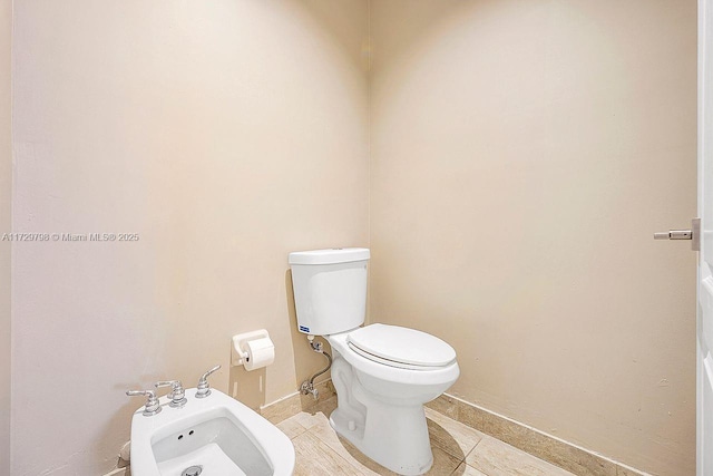 bathroom with a bidet, tile patterned floors, and toilet