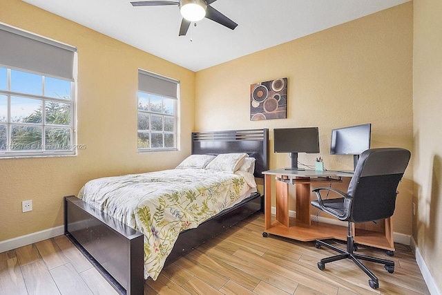 bedroom with light wood-type flooring and baseboards