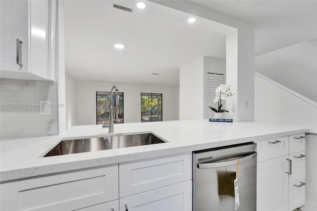 kitchen with white cabinetry, sink, light stone counters, and dishwashing machine